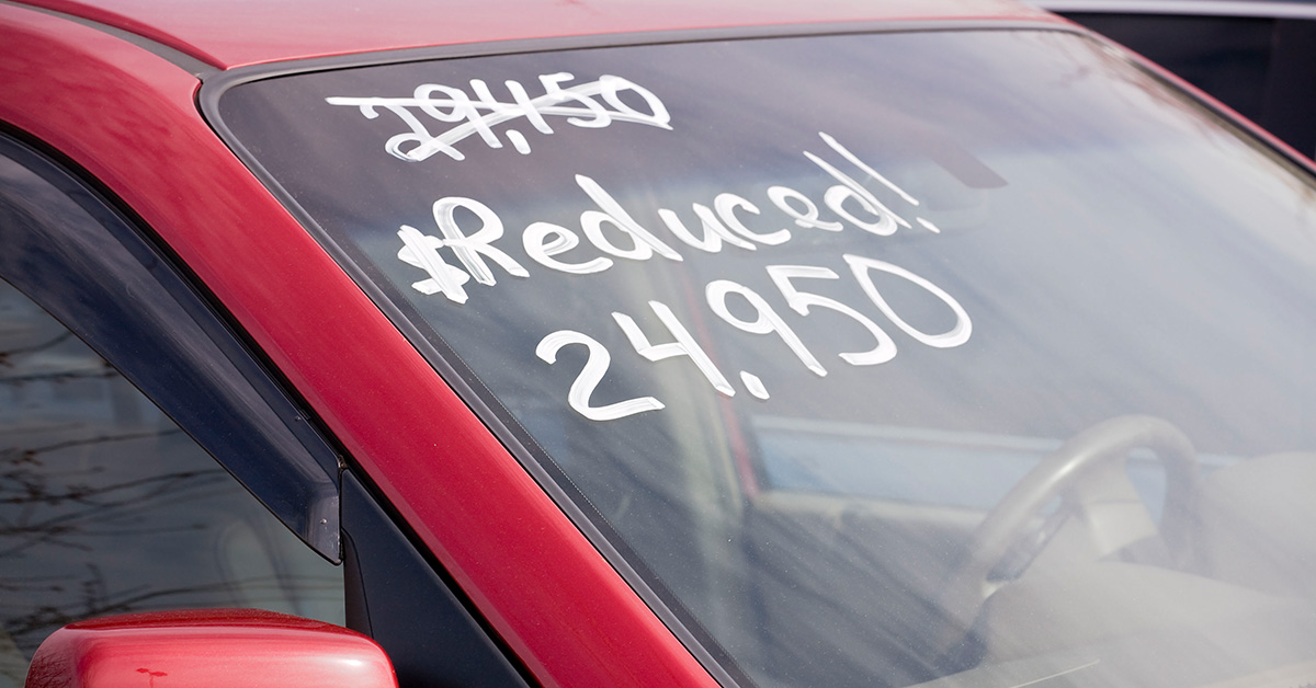 older-used-vehicle-with-price-adjusted-on-windshield