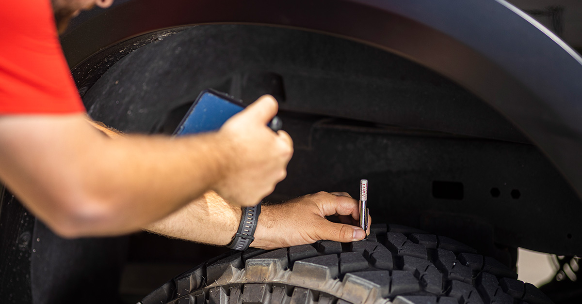 Inspector looking at car wheel