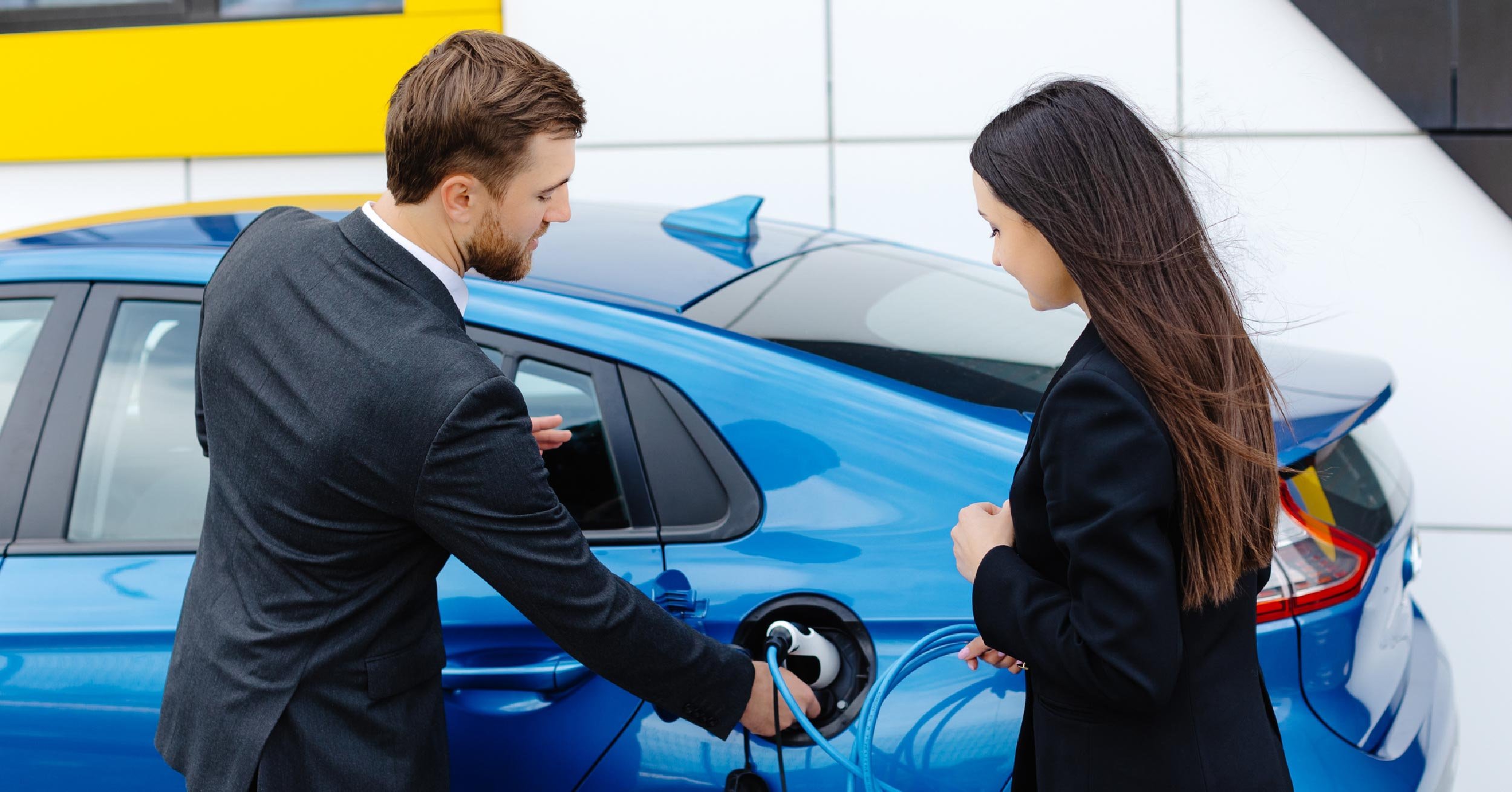 car-dealer-showing-ev-to-millenial-or-gen-z-woman