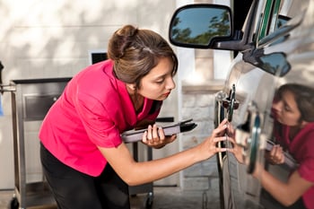 Woman checking condition of vehicle