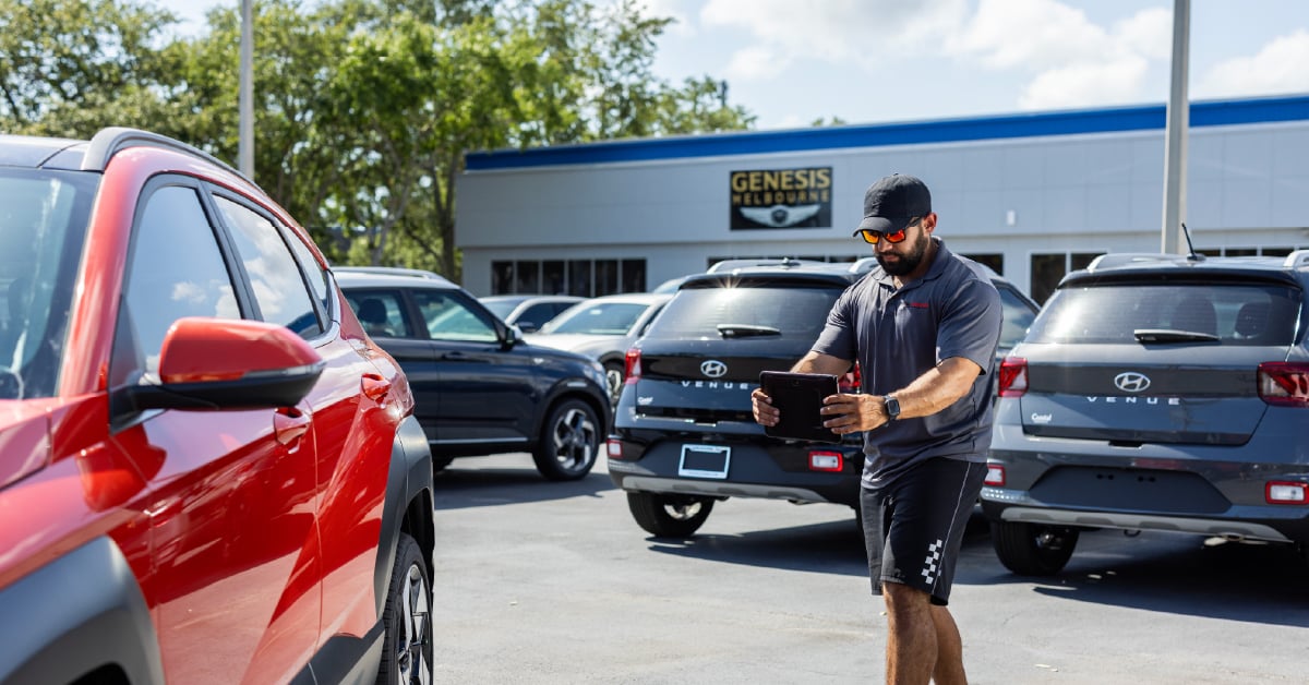 Car photographer shooting a vehicle on a dealership lot