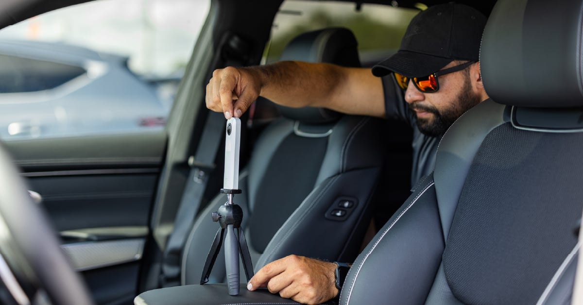 Car dealership photographer using 360 video camera inside car